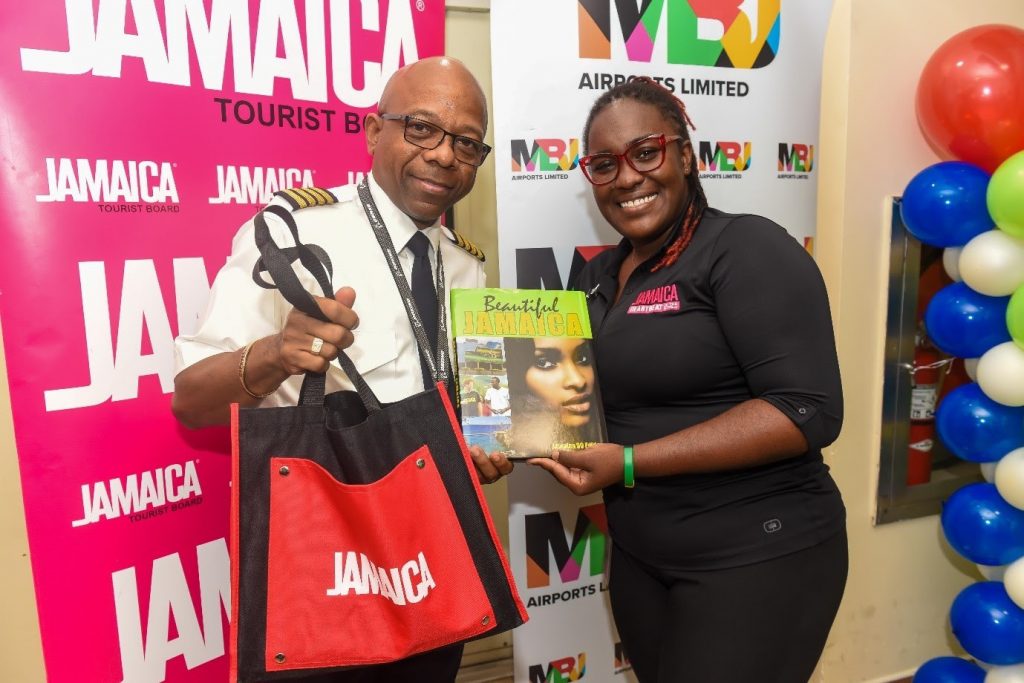 Pictured: Acting Visitor Relations Manager, Jamaica Tourist Board, Candessa Cassanova presents Captain Leon Missick with gifts following the flight’s arrival into Sangster International Airport.