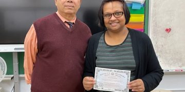 A happy Devi with her GED diploma