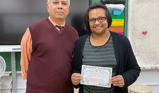 A happy Devi with her GED diploma