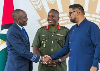 First Officer Haslyn Peters shakes the hand of President Irfaan Ali, as Chief of Staff of the Guyana Defense Force, Brigadier General Godfrey Bess, looks on.