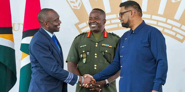 First Officer Haslyn Peters shakes the hand of President Irfaan Ali, as Chief of Staff of the Guyana Defense Force, Brigadier General Godfrey Bess, looks on.