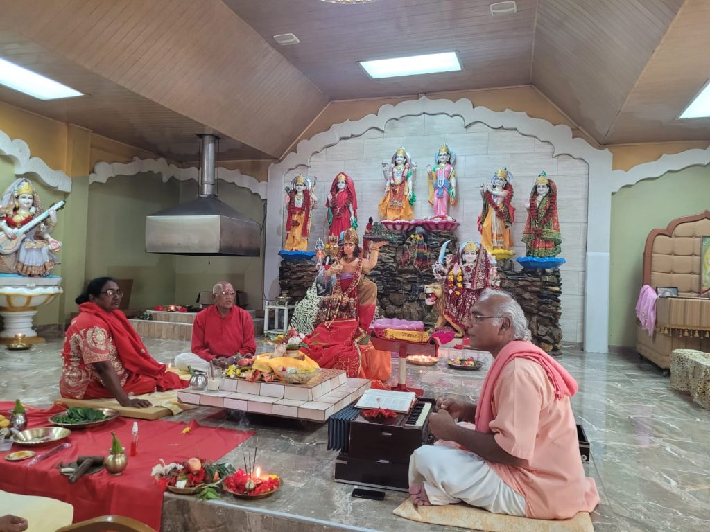 Pandit Vigyan and devotees perform puja