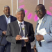 Ashook Ramsaran (center) with award to Dr. David Dabydeen presented by Queens College Alumni Association president John Campbell (right). Event moderator Roberts on the left.